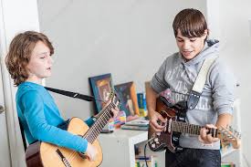 Kids having fun playing guitar together