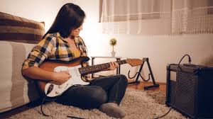 teen girl having fun playing the guitar